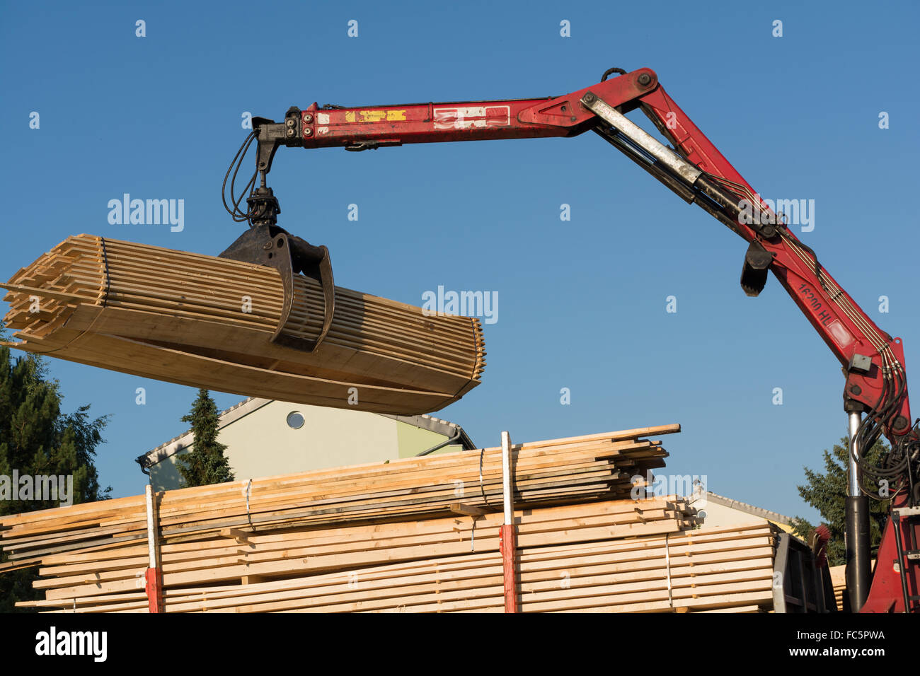 Truck crane lifts with gripper Timber Stock Photo