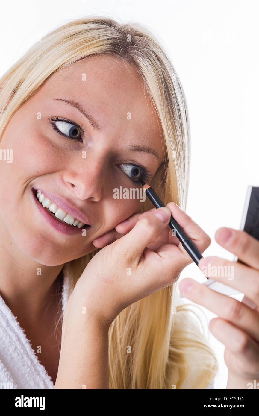 Young woman with eyeliner in hand Stock Photo