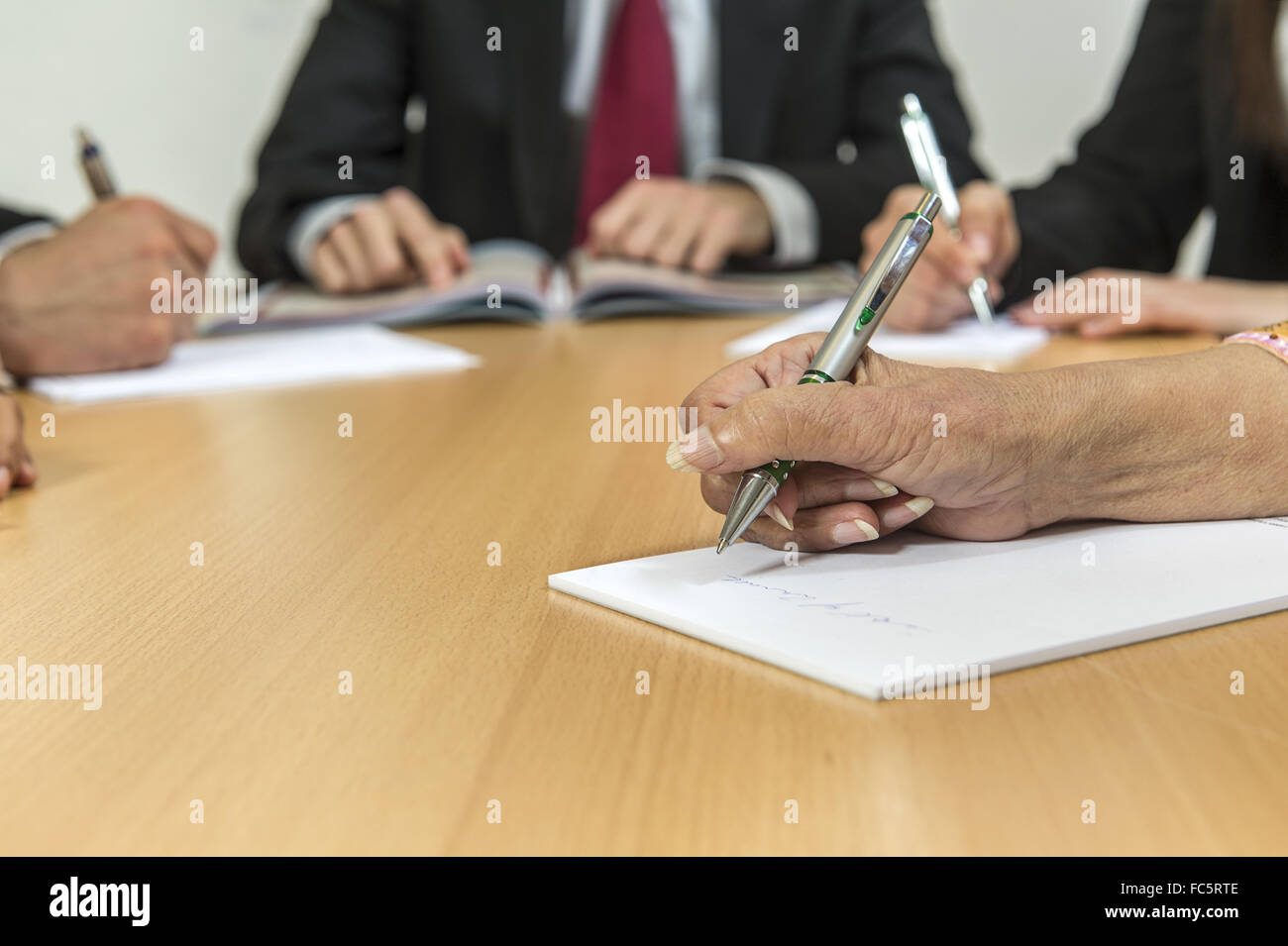 Hands with pen on a desk Stock Photo