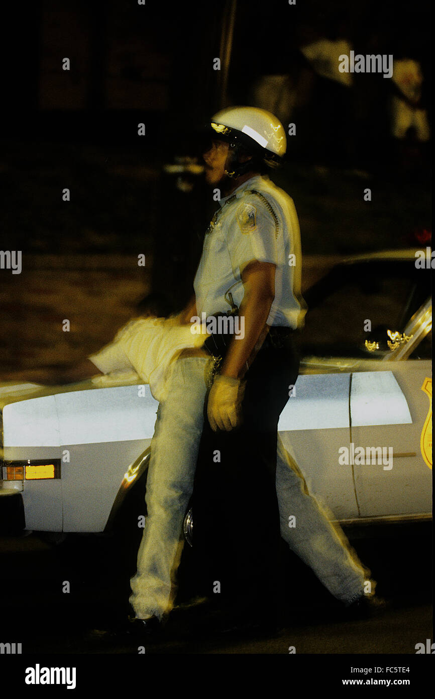 Washington, DC., USA, 1991 DC. Police officer restrains suspect at scene of a shooting. Credit