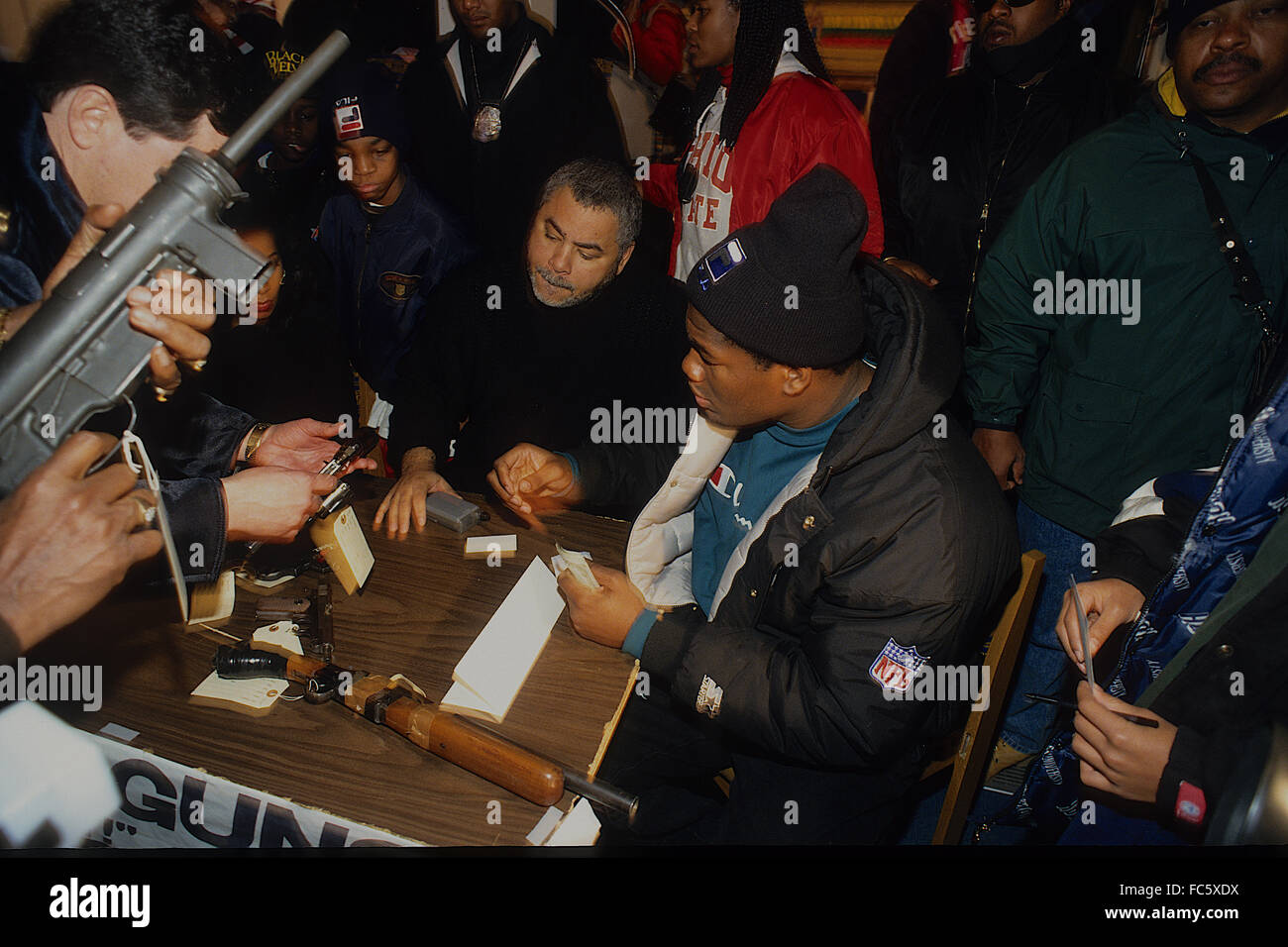 Washington, DC., USA, 15th January, 1994 Heavyweight fighter Riddick Bowe (in black watch hat and green shirt at end of table) pays one hundred dollars for each gun turned in no questions asked. He ended up buying back 3,600 guns.  Credit: Mark Reinstein Stock Photo