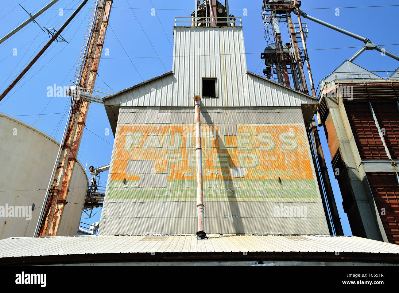 A metal storage elevator sports a dated, peeling sign that links it to another era. Lawndale, Illinois, USA. Stock Photo