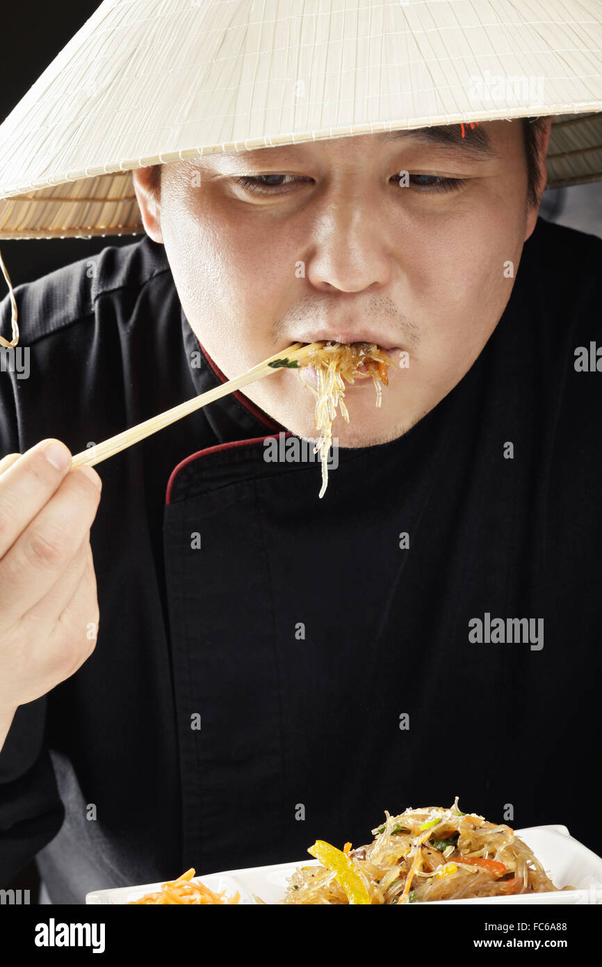Guy in straw hat eating Stock Photo Alamy