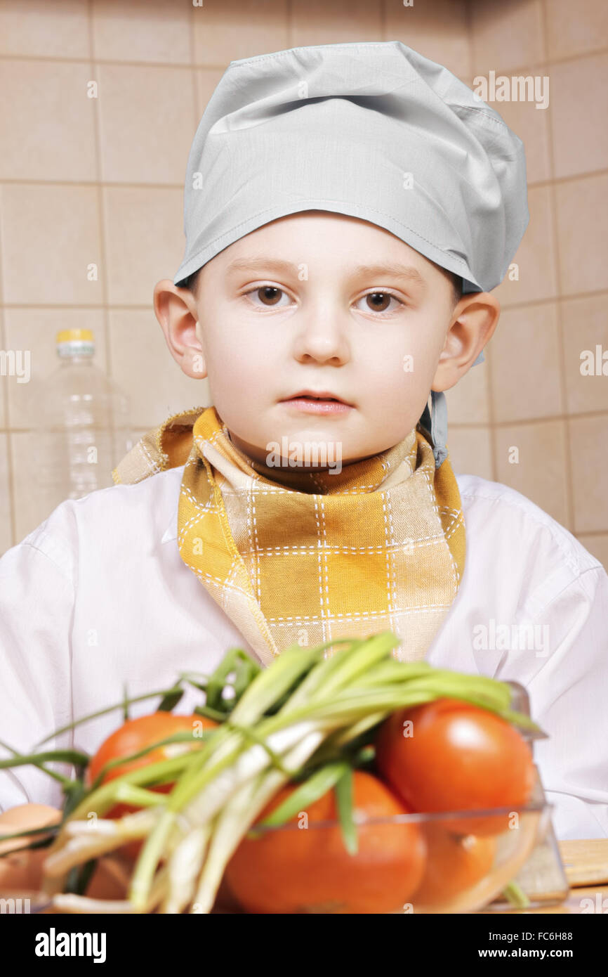 Portrait of little cook with tomatoes Stock Photo