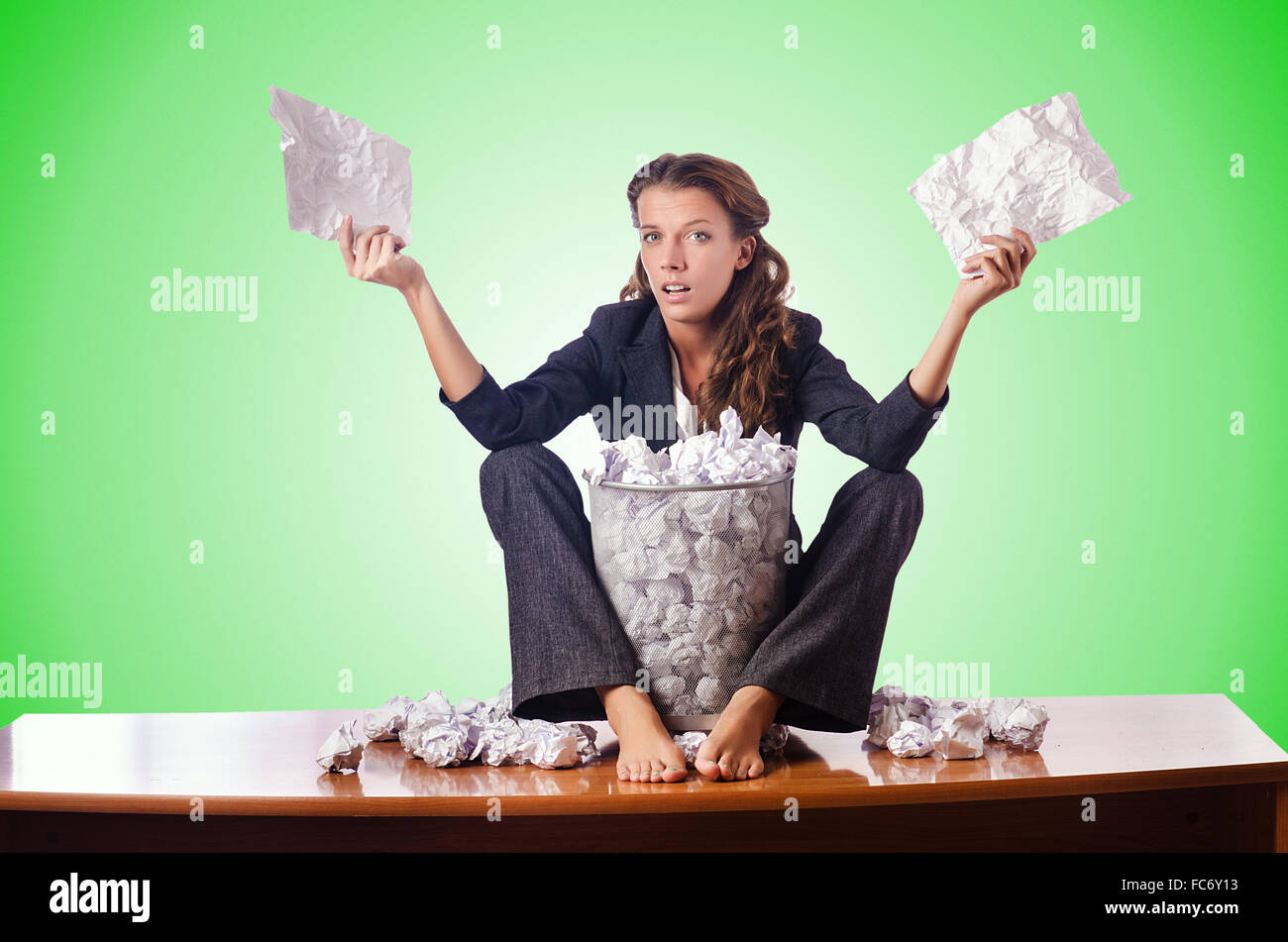 Woman with lots of discarded paper Stock Photo