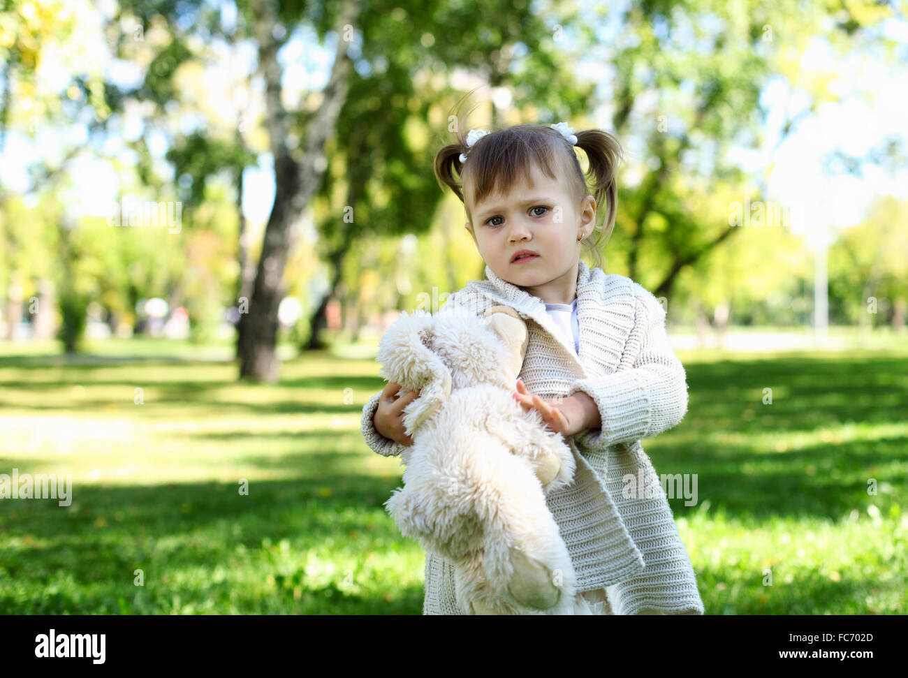 Portrait of a little girl playing in green summer park Stock Photo - Alamy