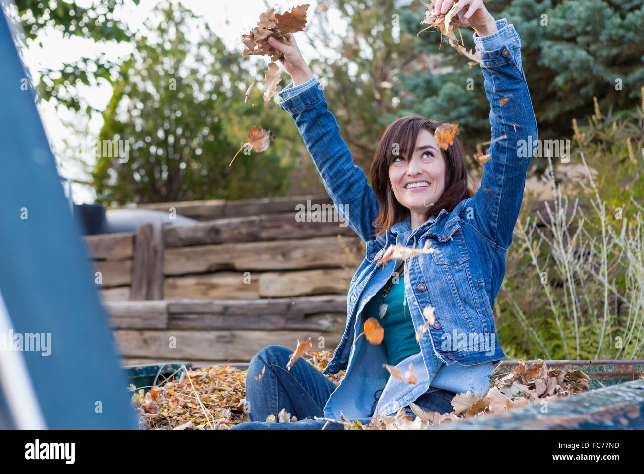 Hispanic woman playing in truck bed Stock Photo
