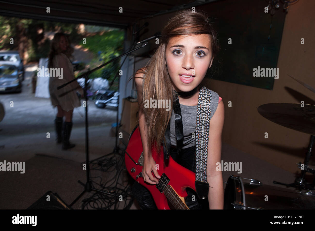 Girl playing guitar in rock band Stock Photo