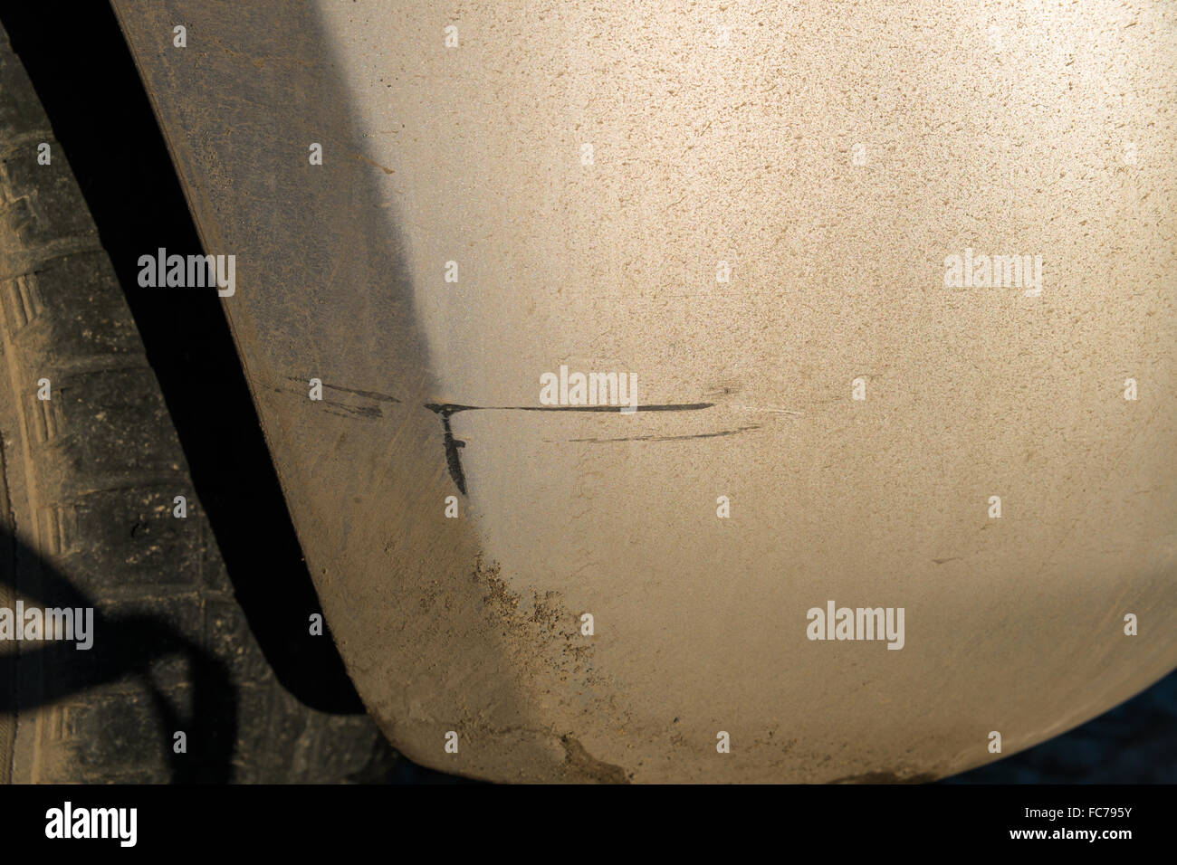 Damage to the paintwork of the car. Scratch on the dirty bumper car Stock Photo