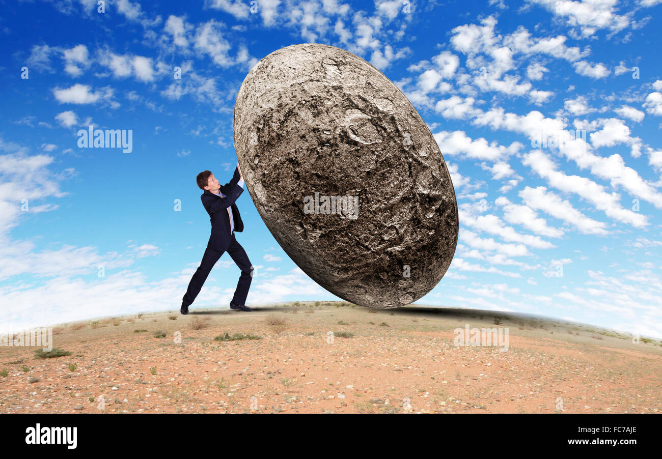Image of businessman rolling a giant stone Stock Photo - Alamy