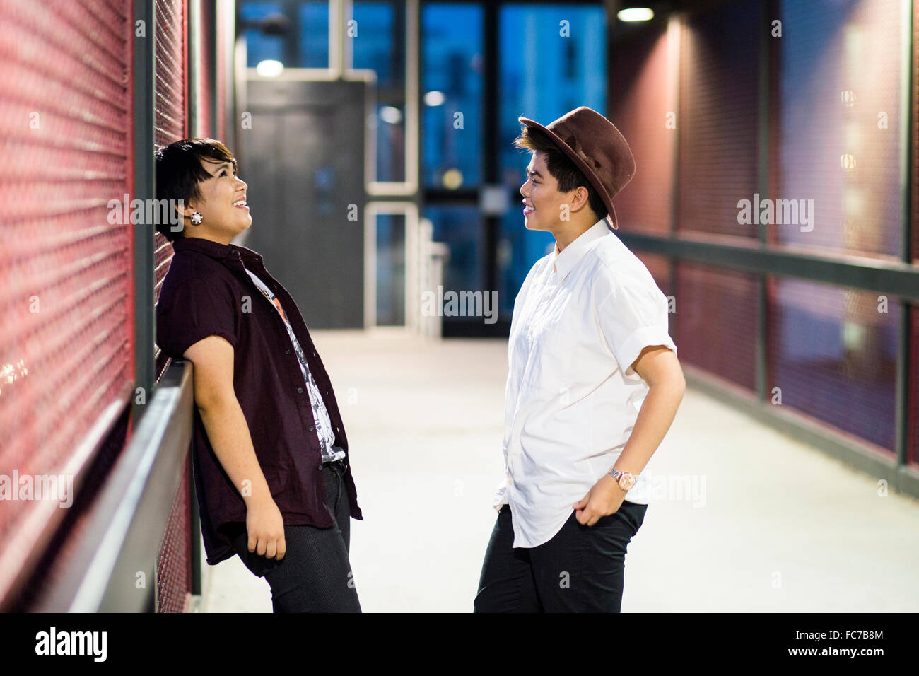 Asian couple talking in hallway Stock Photo