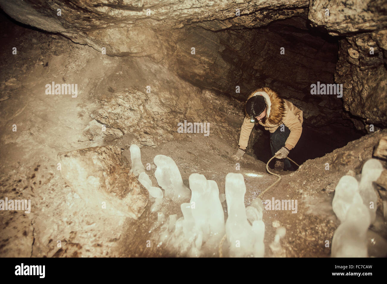 Caucasian hiker climbing in cave Stock Photo