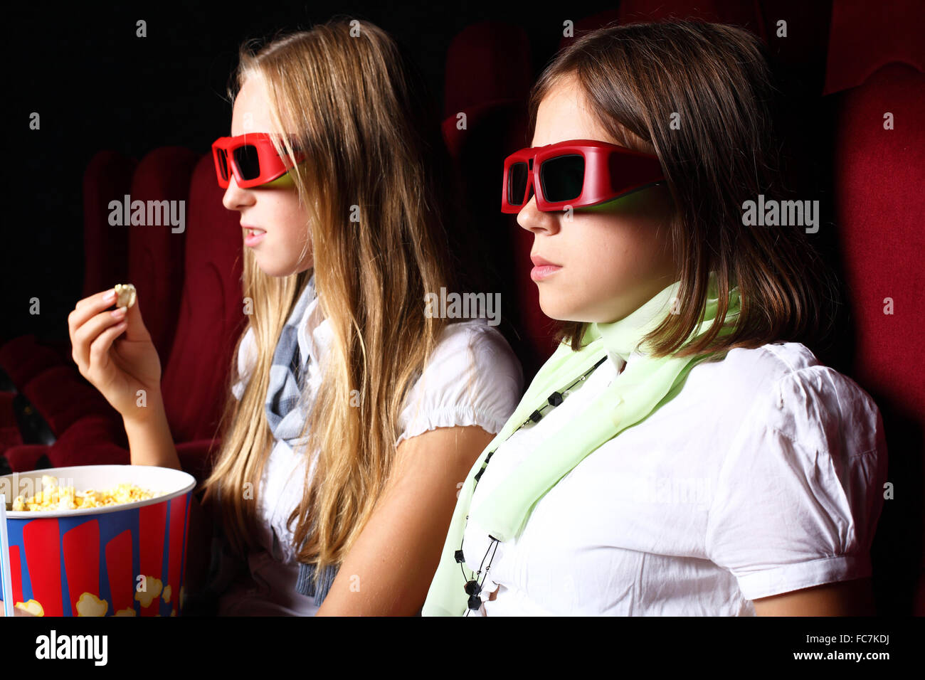 Two young girls watching movie in cinema Stock Photo Alamy