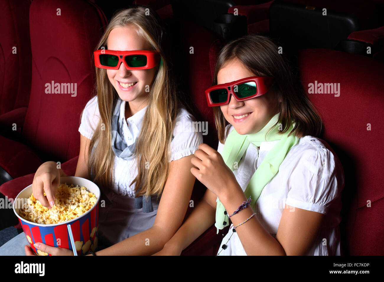 Two young girls watching movie in cinema Stock Photo Alamy