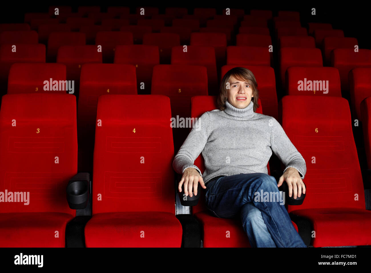 Young man sitting in cinema and watching movie Stock Photo Alamy
