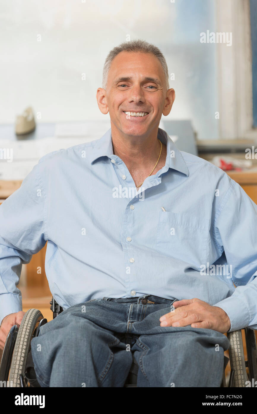Caucasian businessman smiling in wheelchair Stock Photo