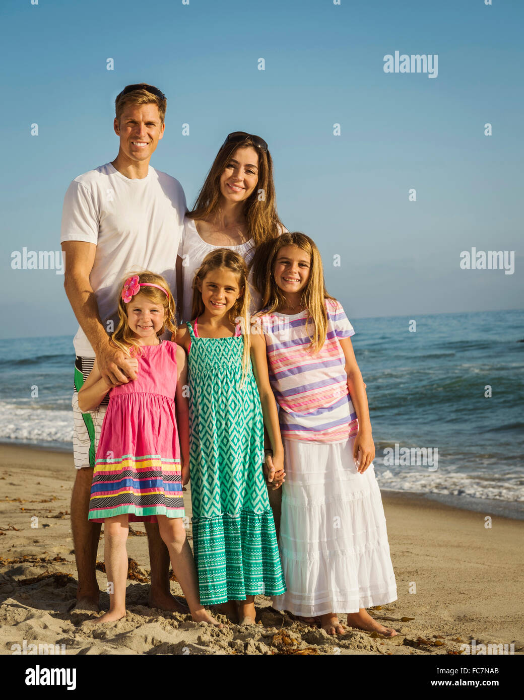 Caucasian family smiling on beach Stock Photo