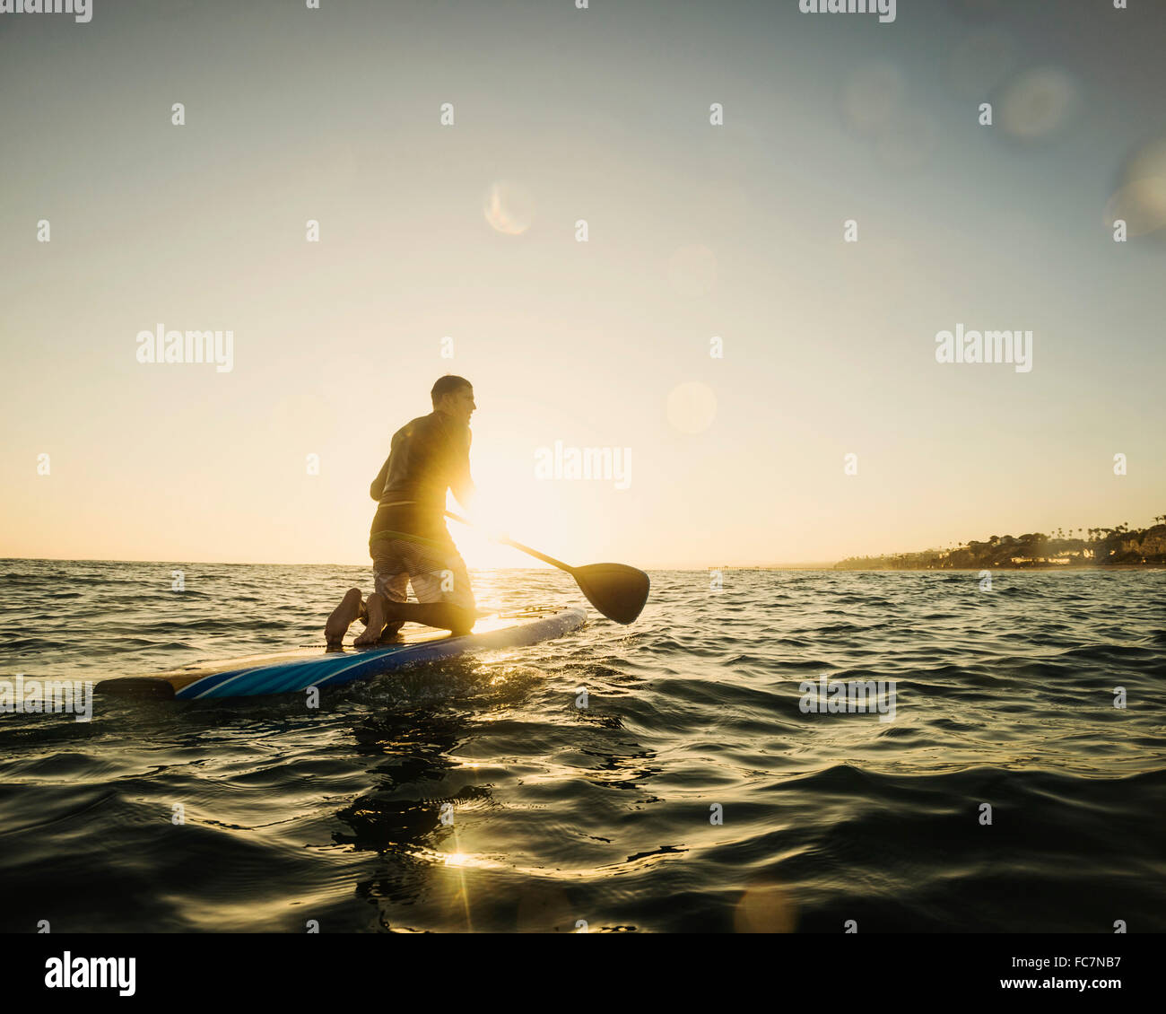 Caucasian man on paddle board in ocean Stock Photo