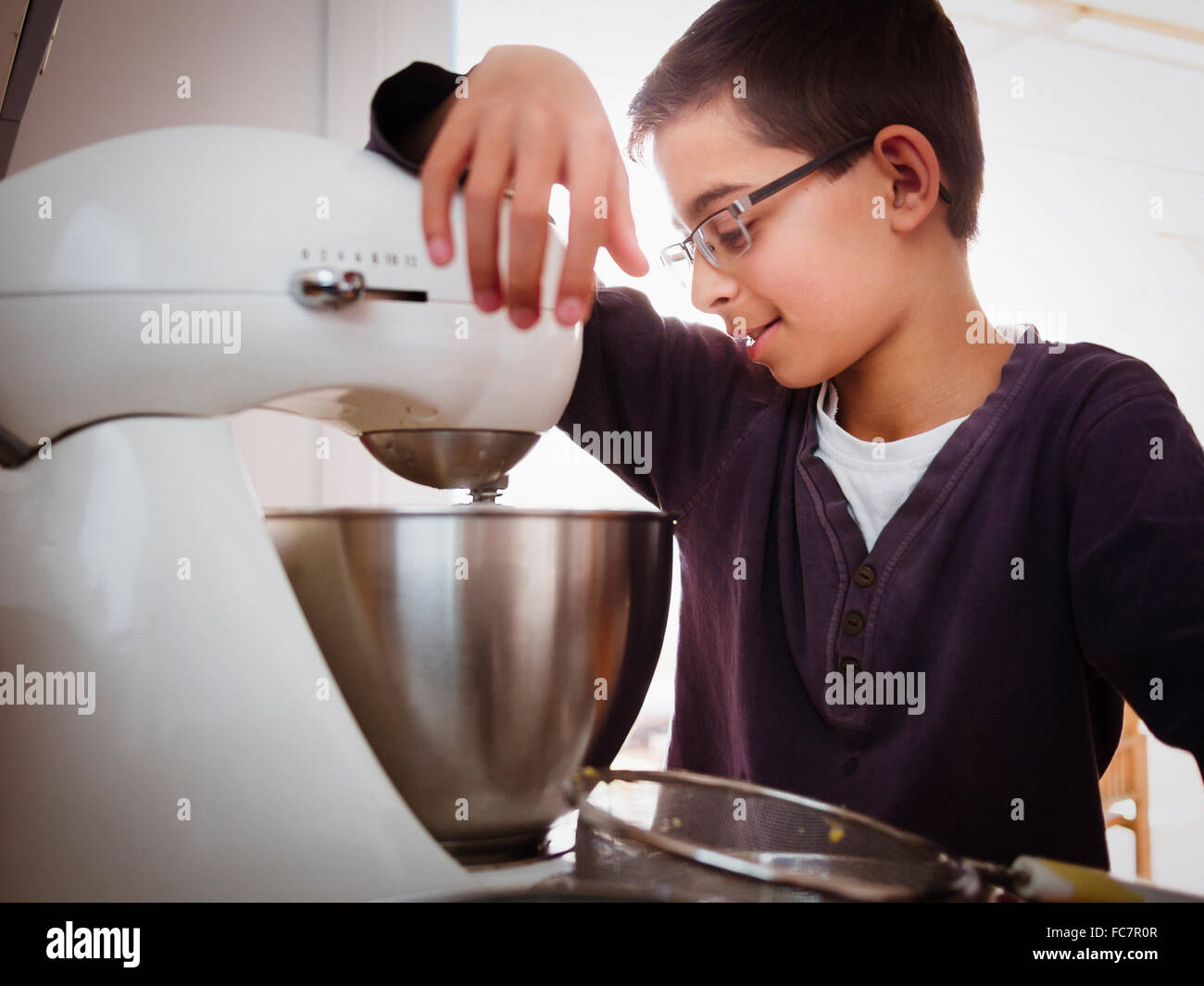 Mixed race boy baking in kitchen Stock Photo