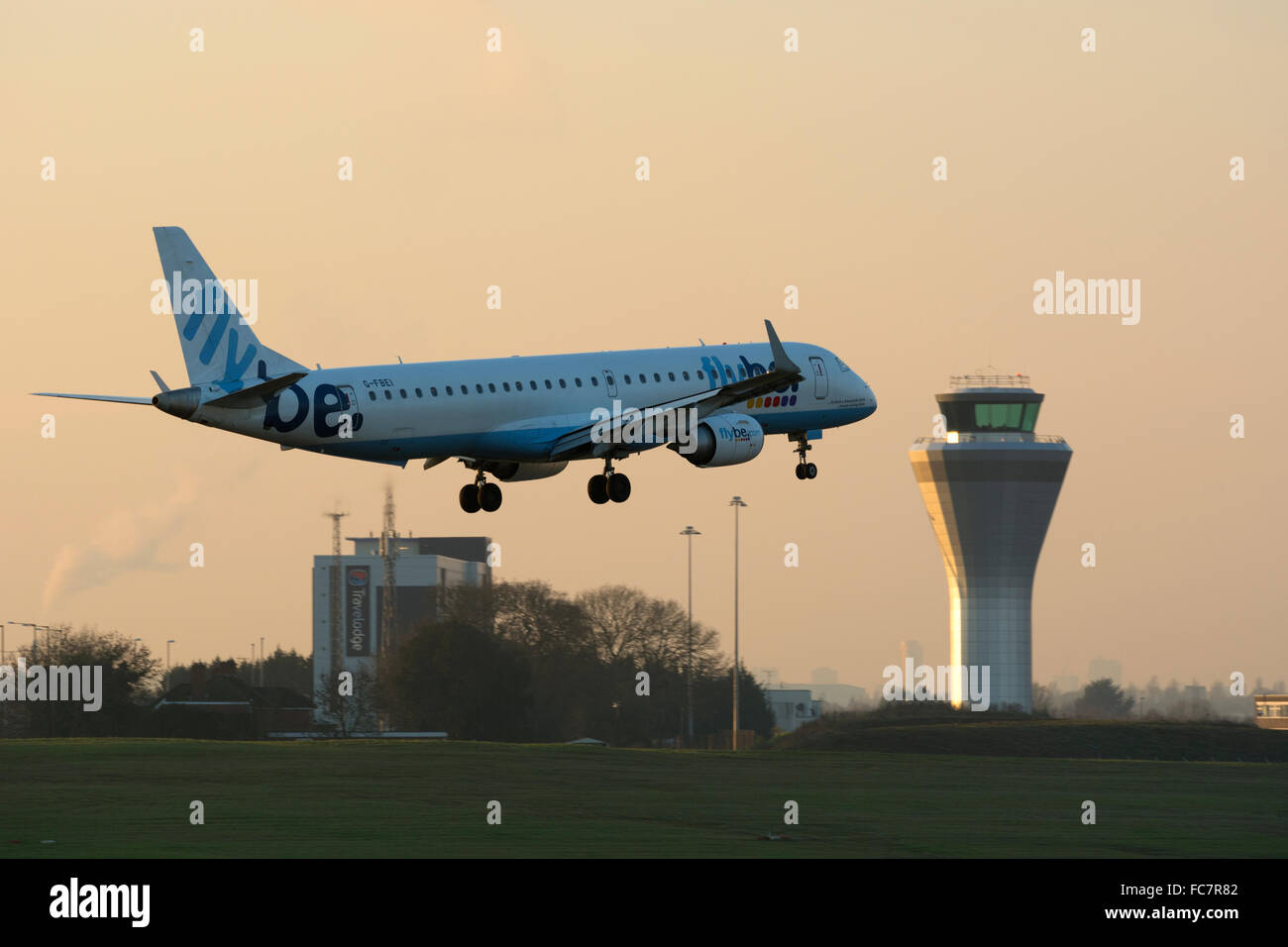 Flybe Embraer ERJ-195 landing at Birmingham Airport at dusk, UK Stock Photo