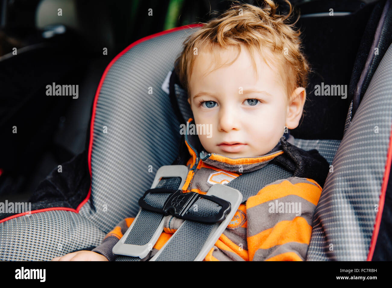 Caucasian boy sitting in car seat Stock Photo