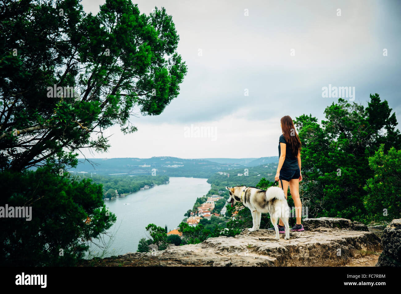 Caucasian woman and dog admiring scenic view Stock Photo