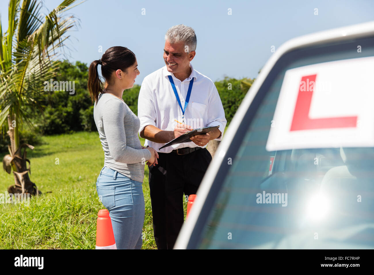 female learner driver and instructor behind a car Stock Photo