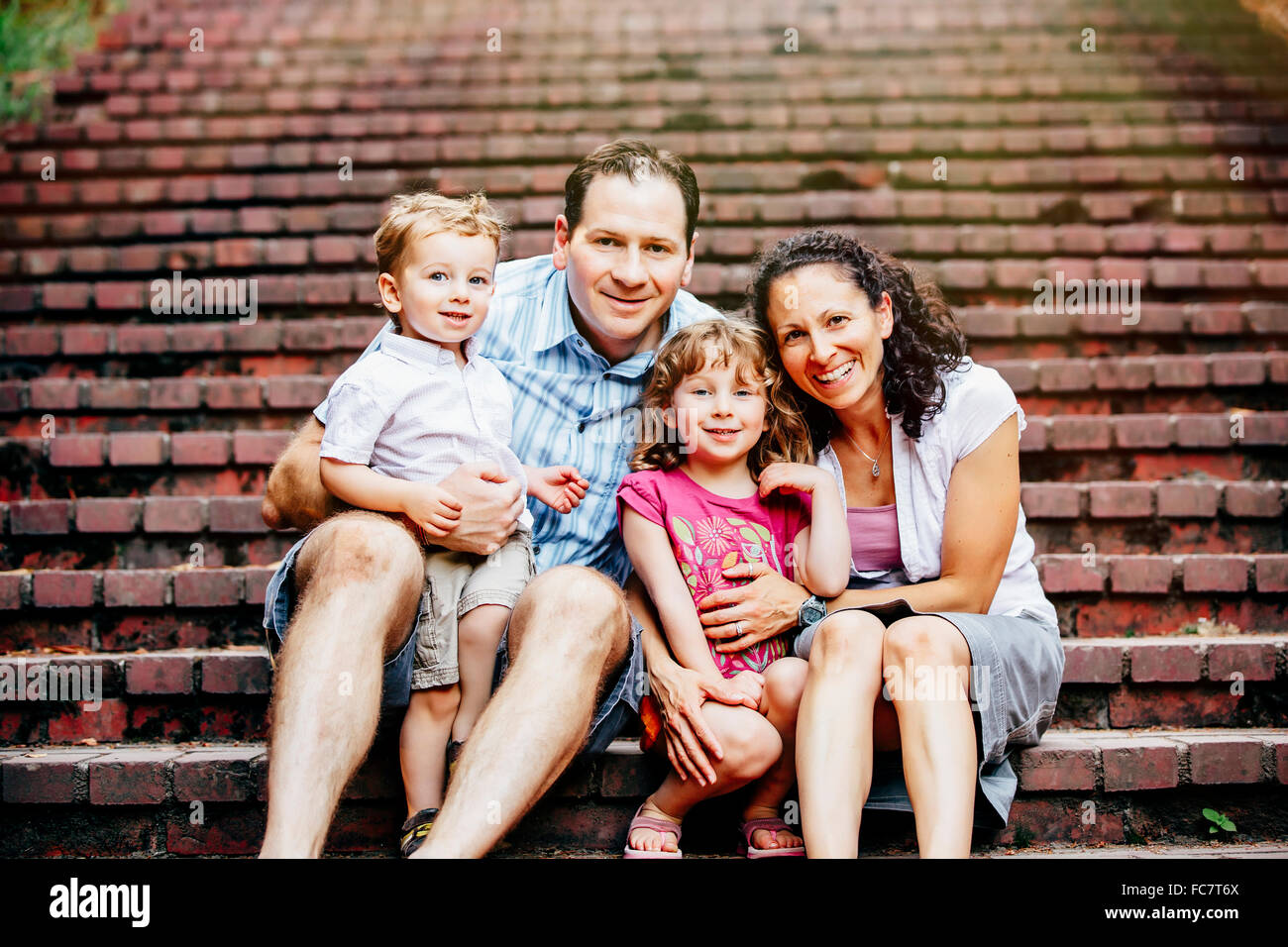 Caucasian family sitting on steps Stock Photo