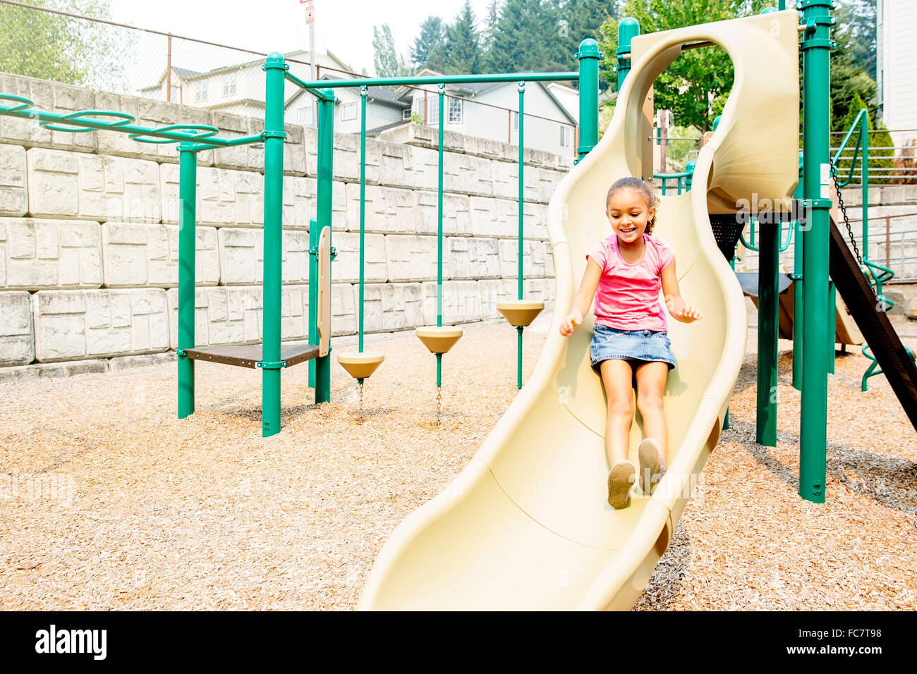 Mixed race girl playing on playground Stock Photo