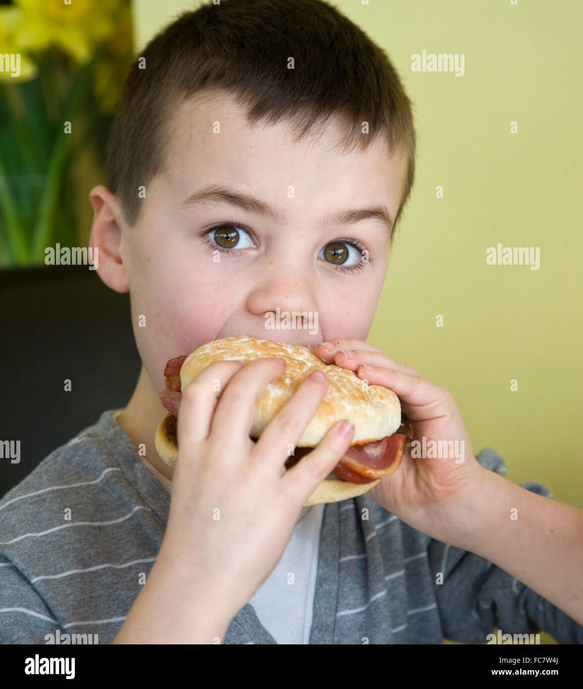 A boy eating a bacon burger Stock Photo Alamy