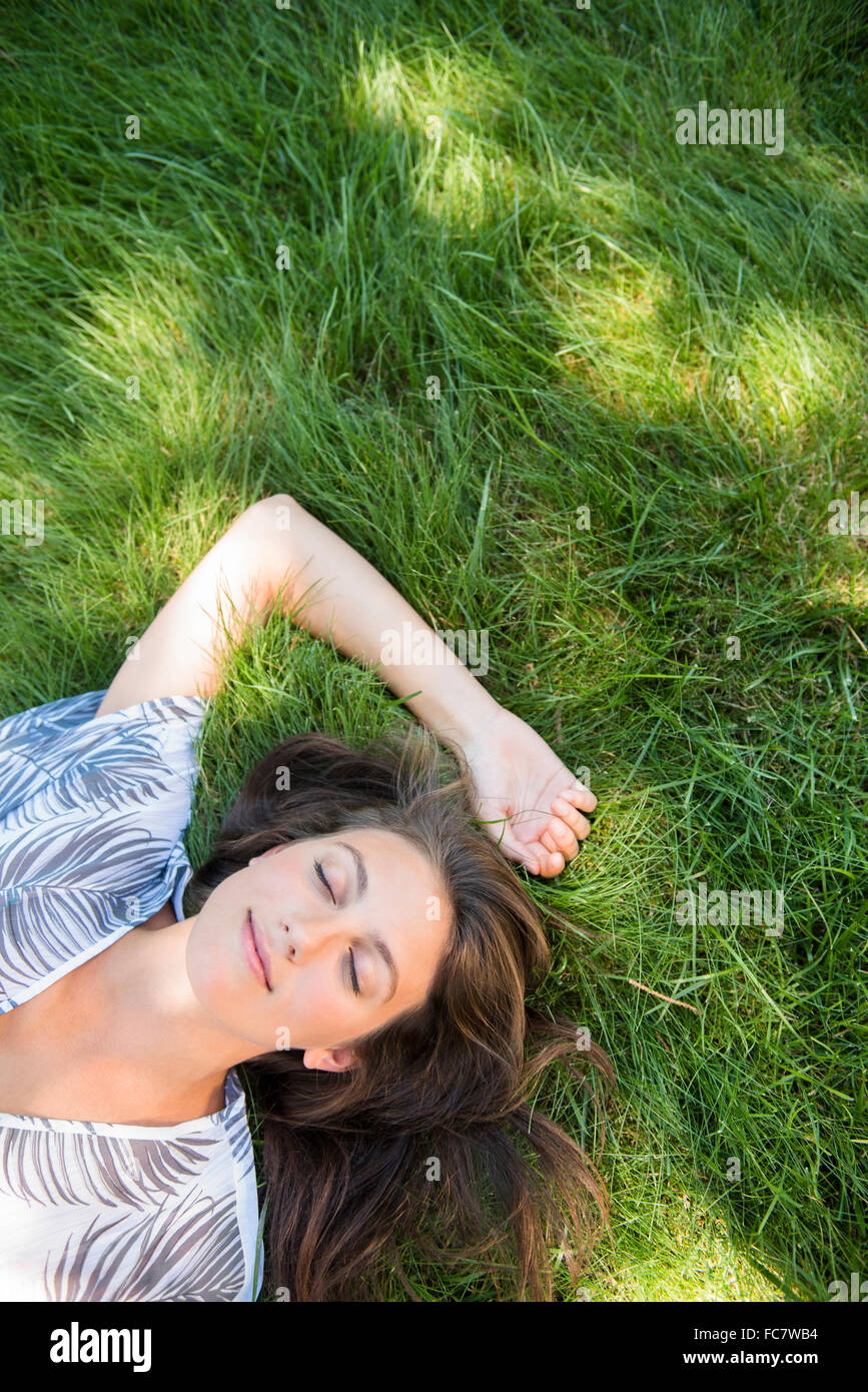 Caucasian woman laying in grass Stock Photo