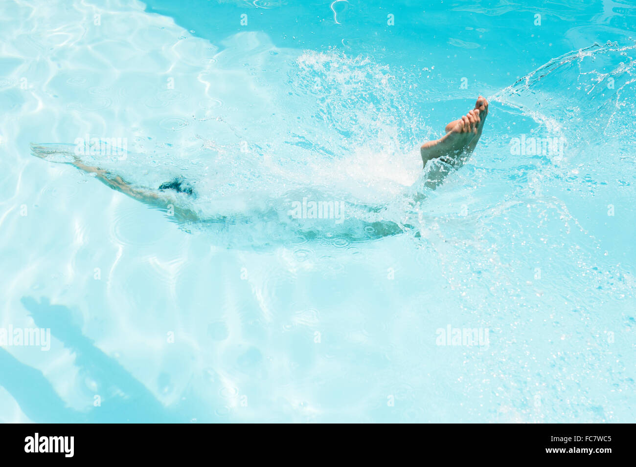 Caucasian woman diving in swimming pool Stock Photo