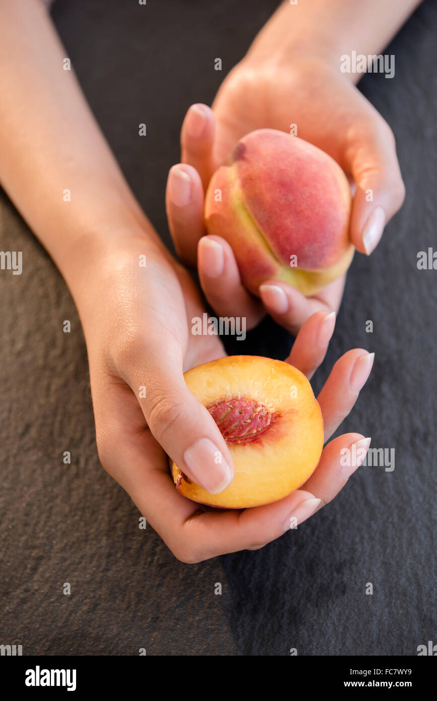 Hispanic woman holding peaches Stock Photo