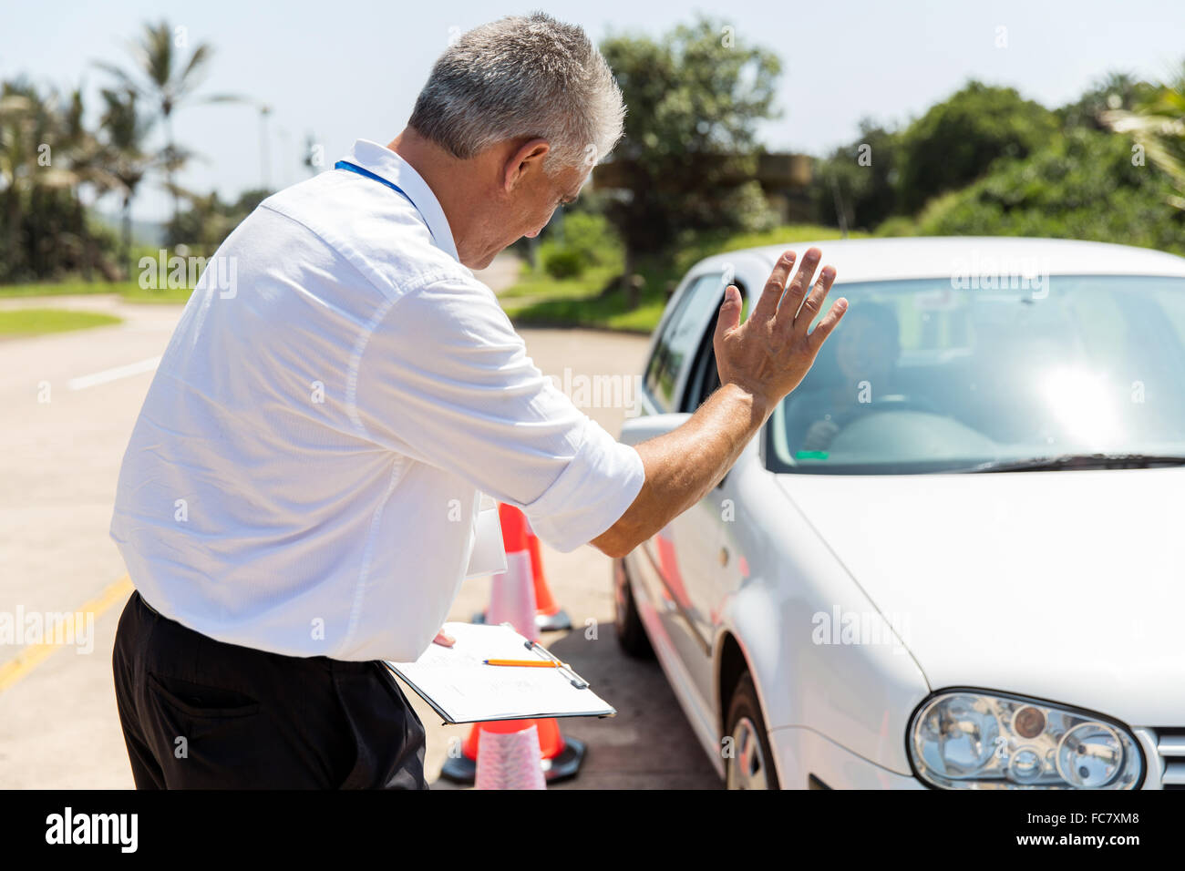 senior instructor teaching learner driver to park a car in testing ground Stock Photo