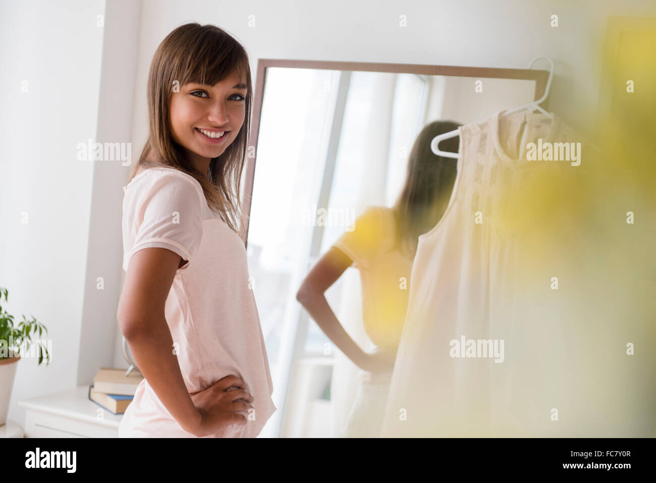 Mixed race woman smiling in front of mirror Stock Photo