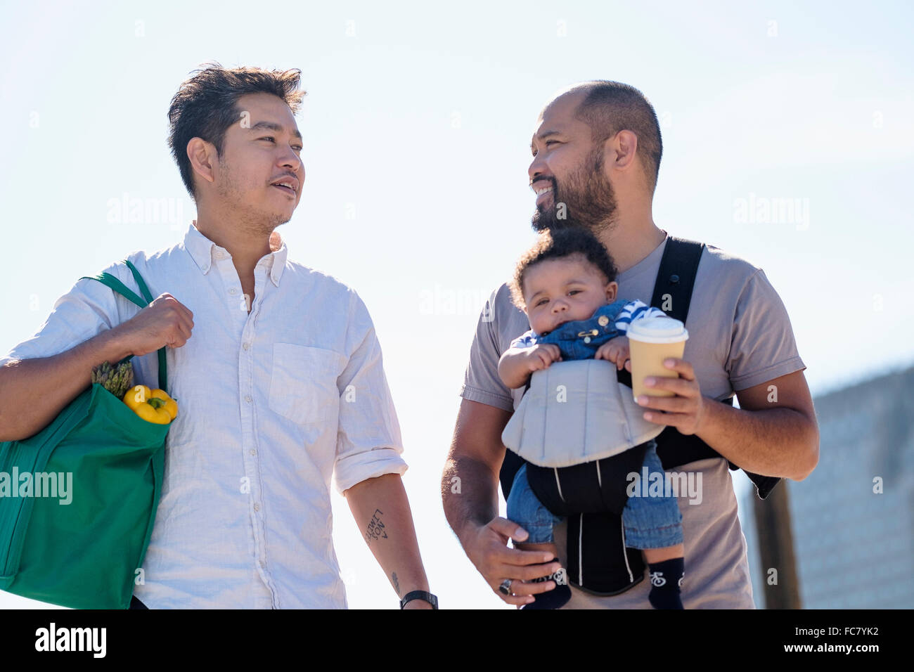 Gay fathers doing errands with baby son Stock Photo