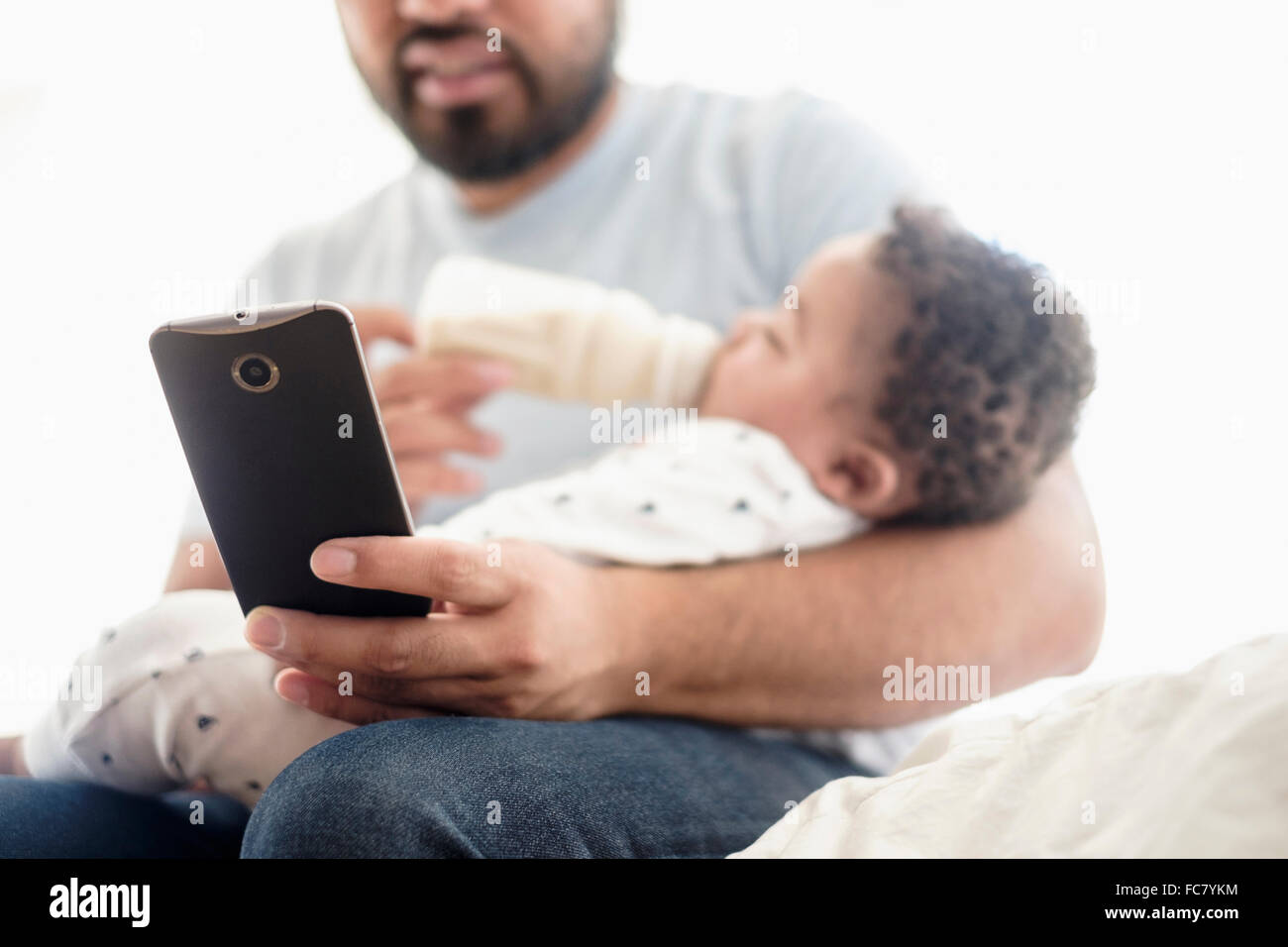 African American man feeding baby son bottle Stock Photo - Alamy