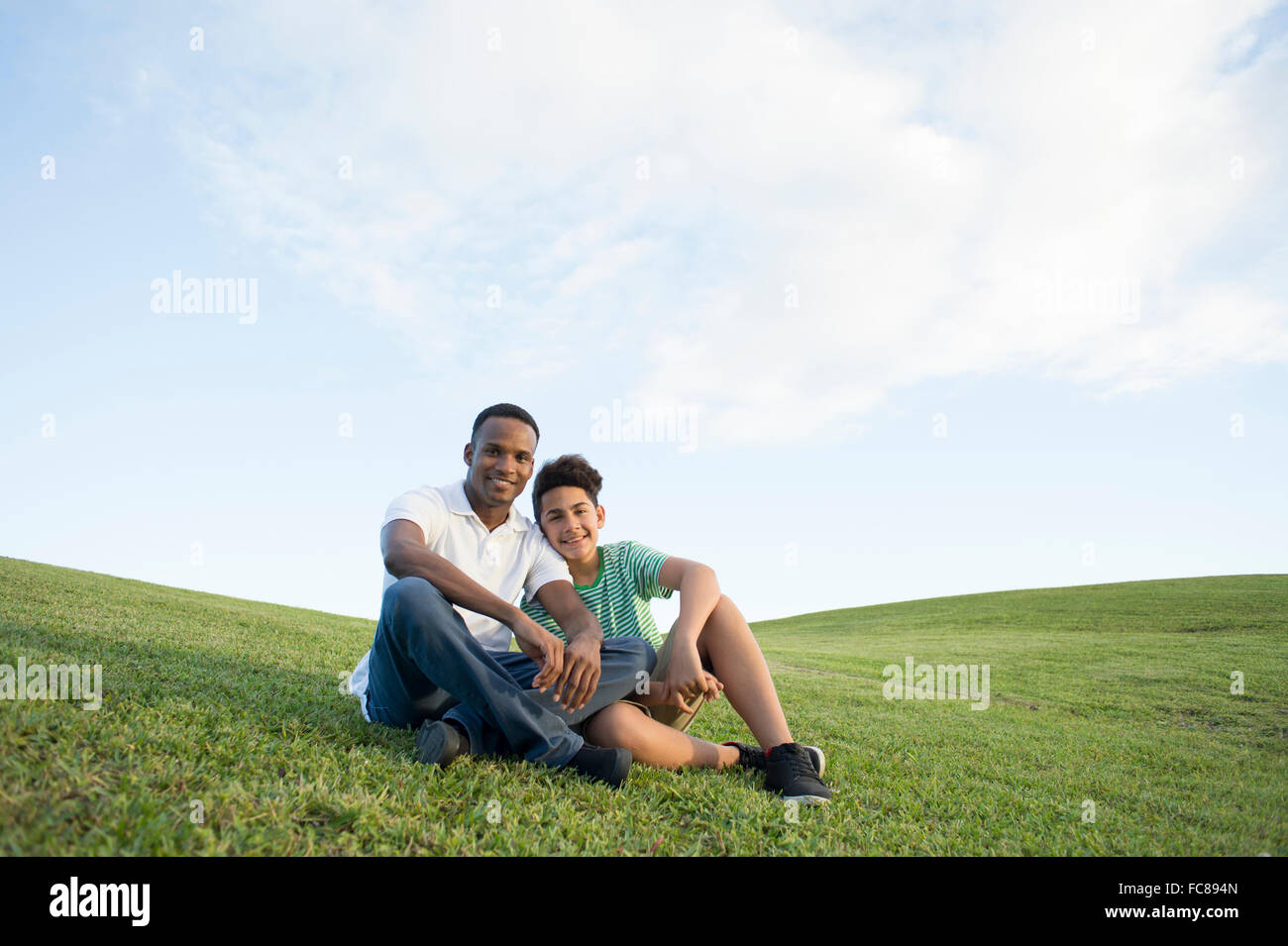 Father and son sitting in grass Stock Photo - Alamy
