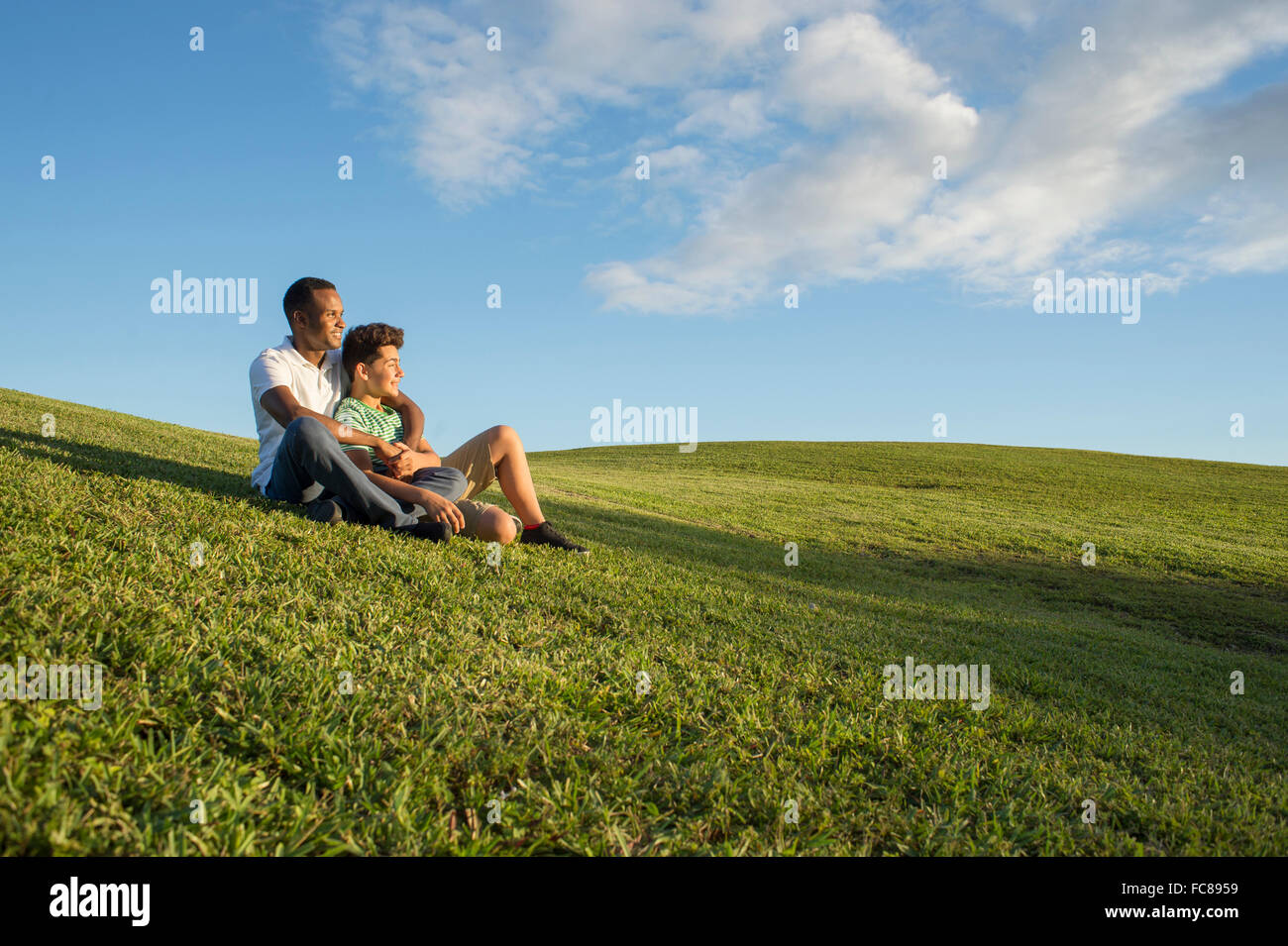 Father and son sitting in grass Stock Photo - Alamy
