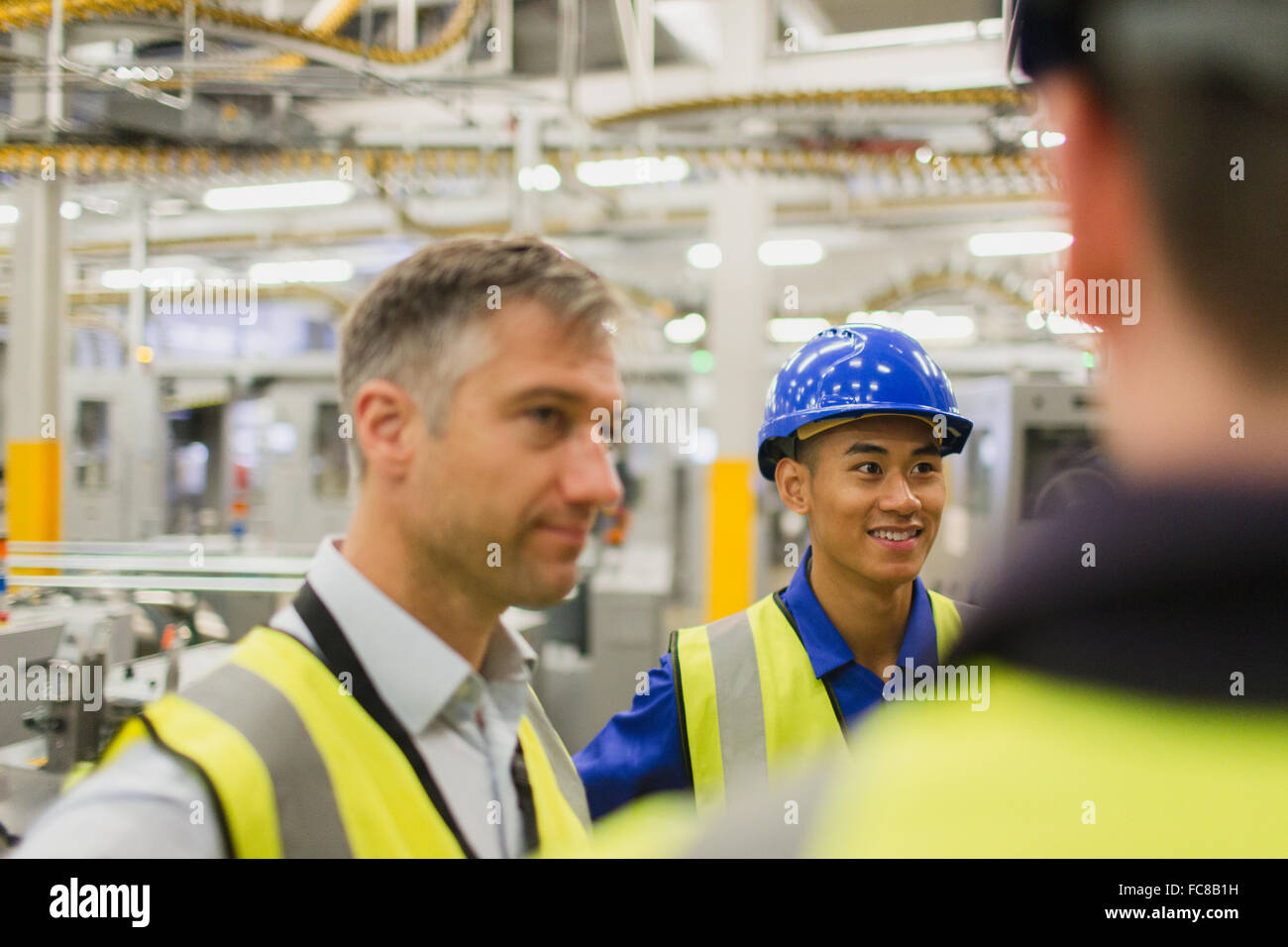 Workers talking in factory Stock Photo