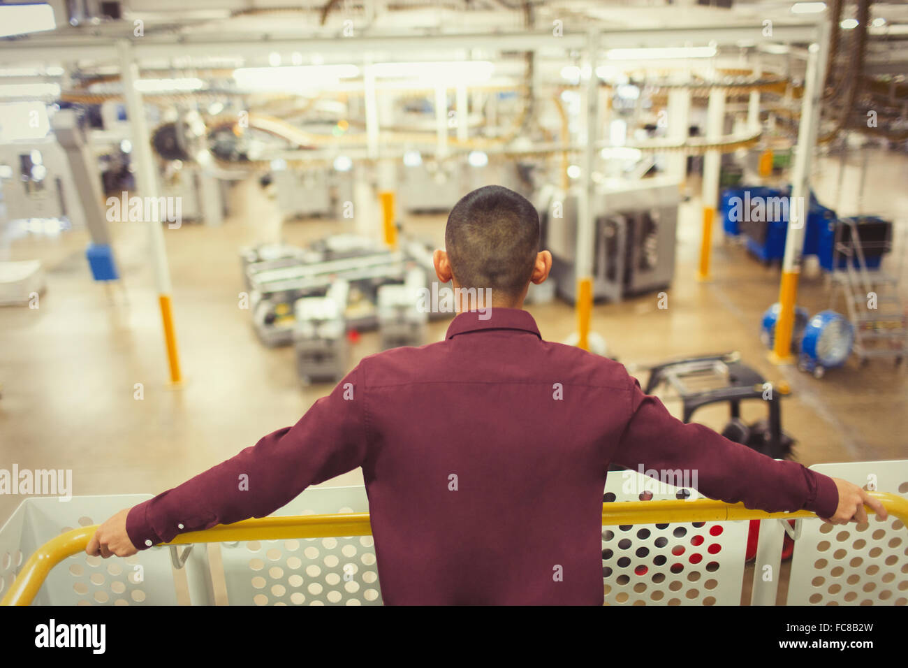 Supervisor on platform looking out over factory Stock Photo