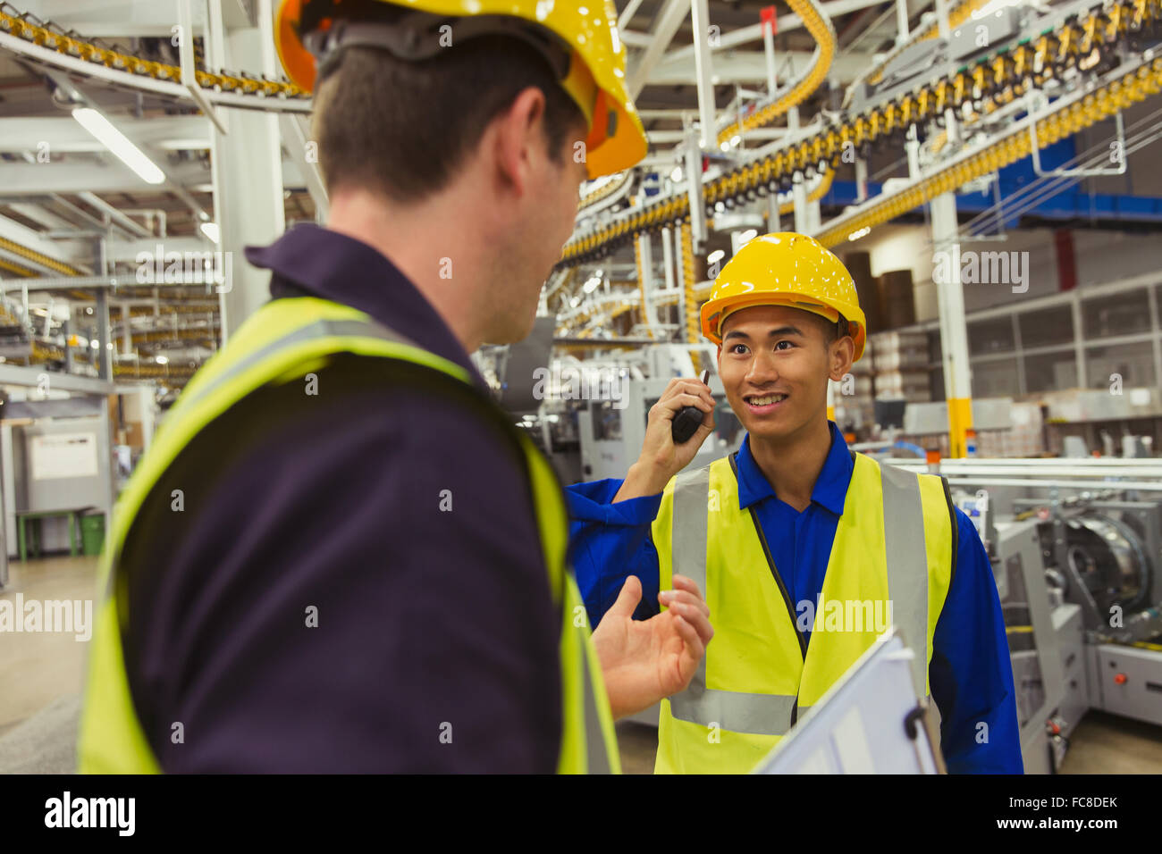 Workers talking in factory Stock Photo