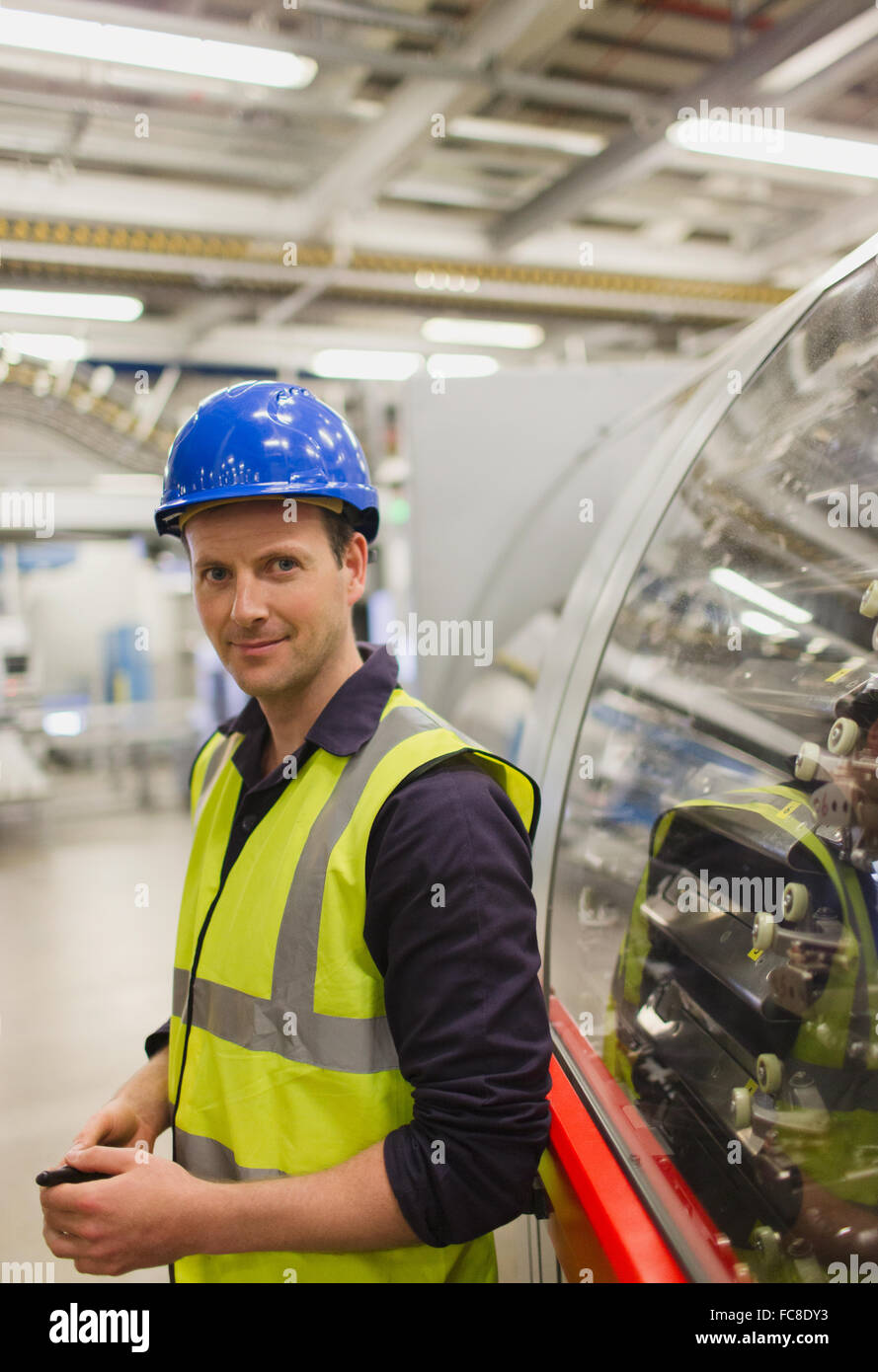 Portrait confident worker leaning on machinery in factory Stock Photo