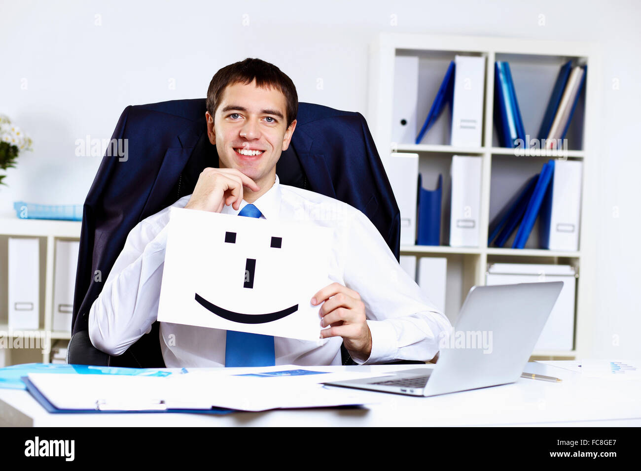 Young smiling happy businessman at work in office Stock Photo - Alamy