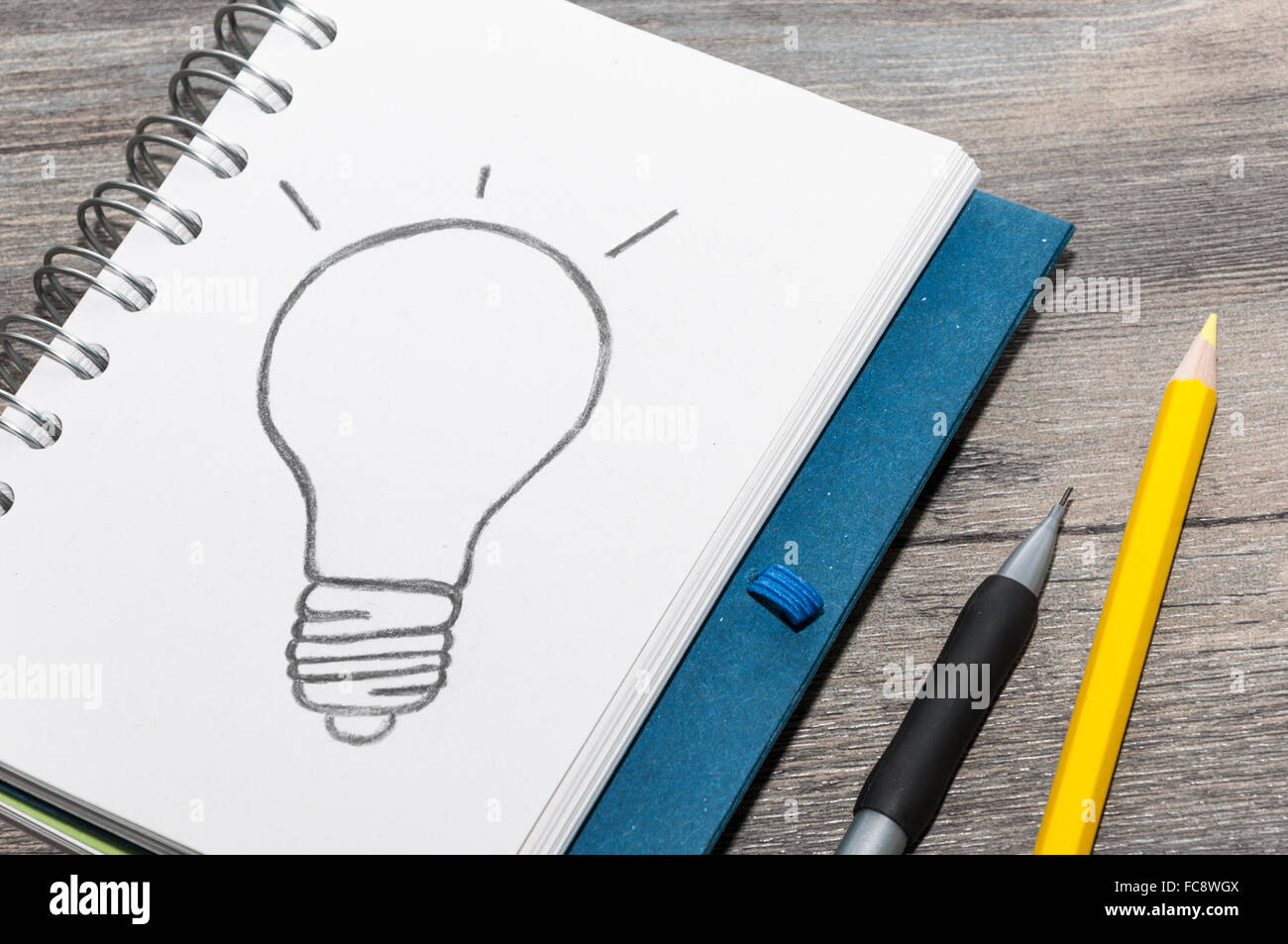 Drawing a bulb on a notepad Stock Photo - Alamy