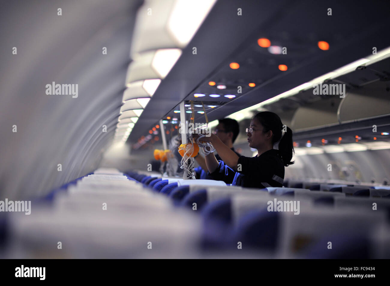 Haikou, China's Hainan Province. 21st Jan, 2016. Staff members check oxygen masks inside a cabin at the maintenance base of China Southern Airlines in Haikou, capital of south China's Hainan Province, on Jan. 21, 2016. China Southern Airlines checked planes and eliminated the hidden dangers to secure the transportation during the Spring Festival travel rush. Credit:  Chu Hongyu/Xinhua/Alamy Live News Stock Photo