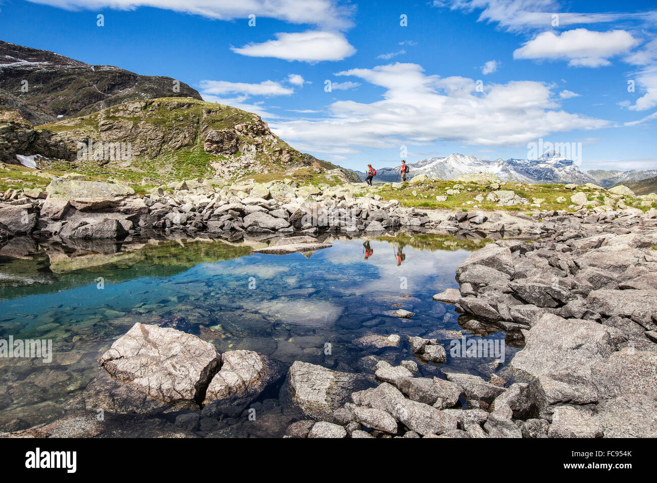 Hikers admire the view at Lake Grevasalvas, Engadine, Canton of Grisons (Graubunden), Switzerland, Europe Stock Photo