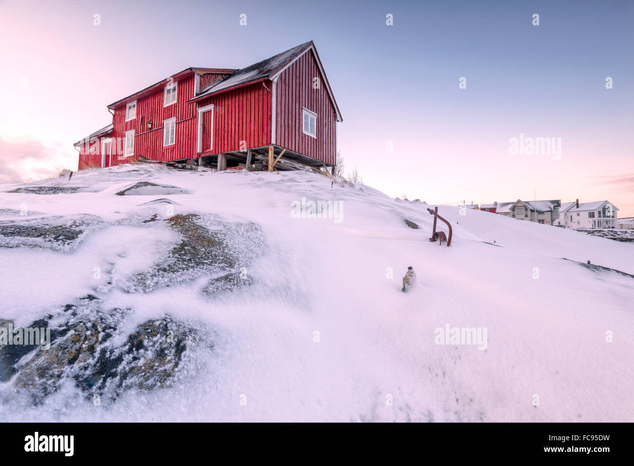 Pink sky on the typical red house of fishermen (rorbu), Henningsvaer, Lofoten Islands, Arctic, Northern Norway, Scandinavia Stock Photo