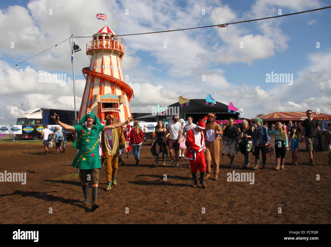 Festival goers embrace the annual fancy dress theme in a muddy field at the Y Not music festival in the Peak District England UK Stock Photo