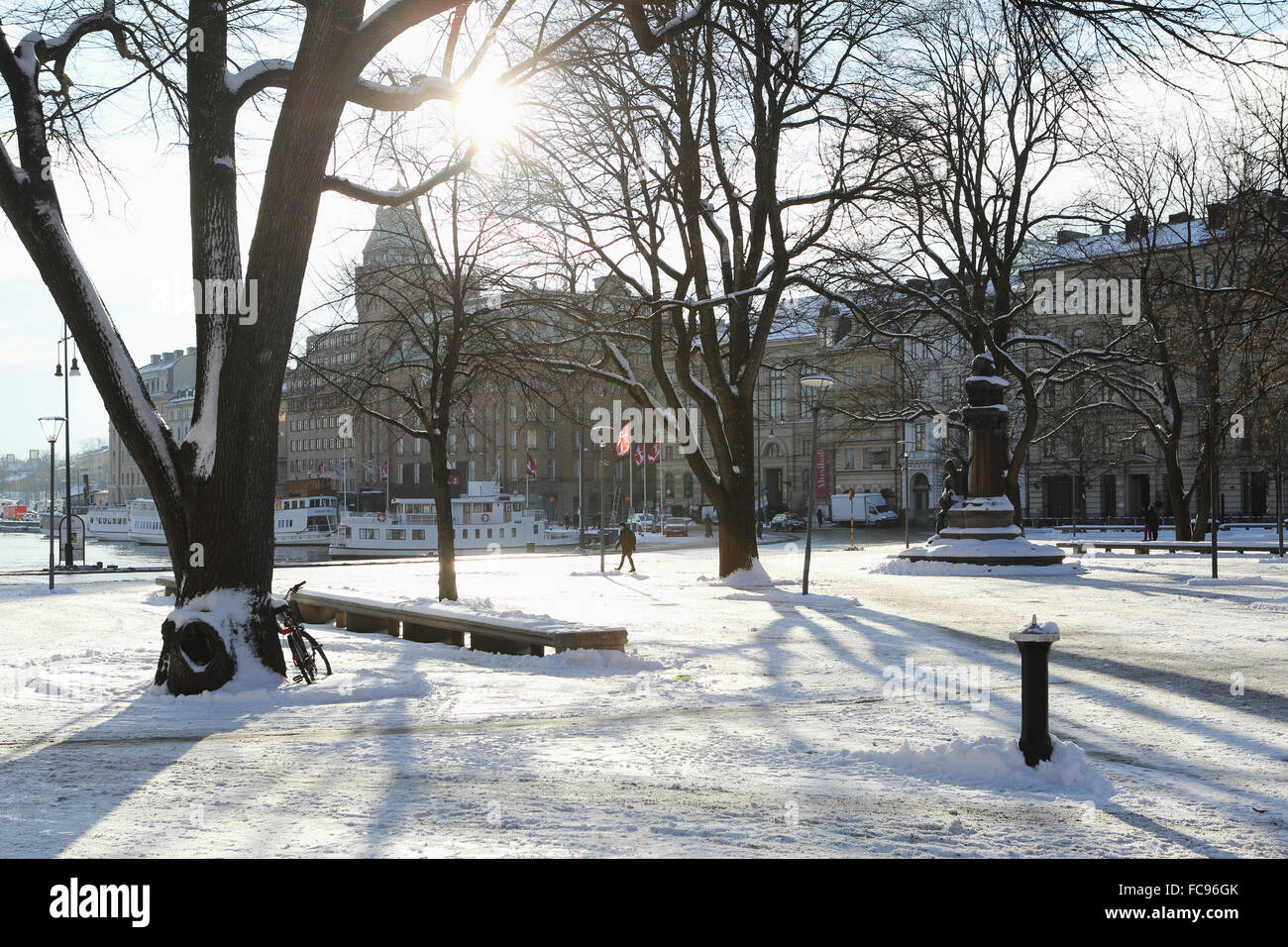 Sunshine in the snow-covered Berzelii Park, by the waterfront at Nybroviken, in Stockholm, Sweden, Scandinavia, Europe Stock Photo